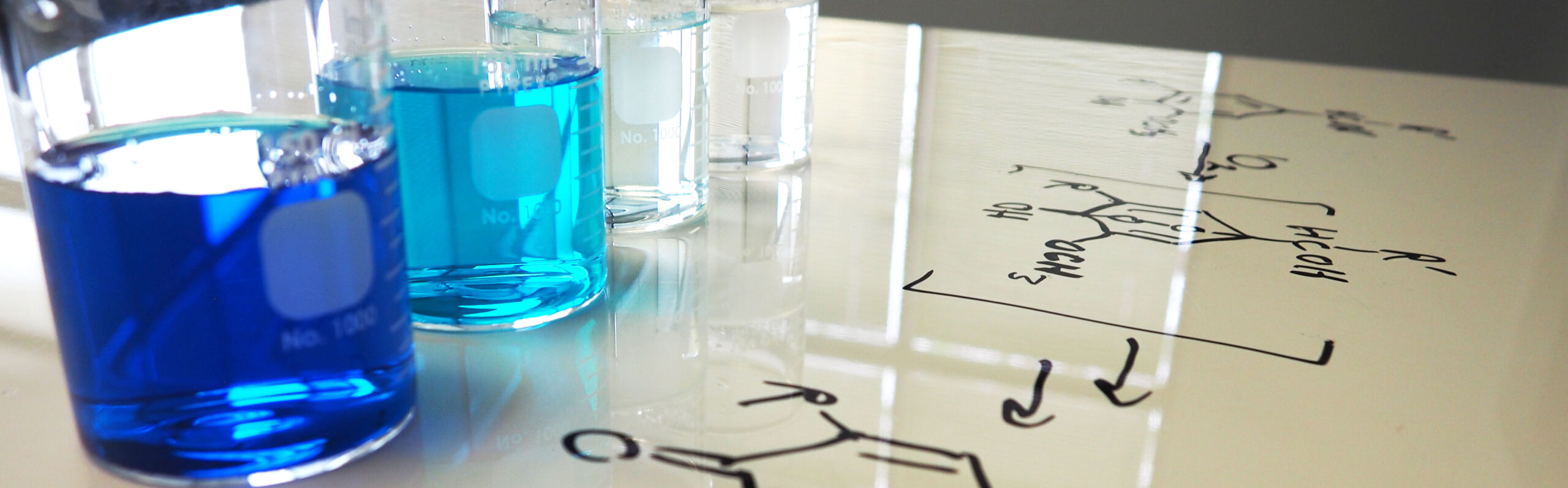 Jars from blue to clear represent PeroxyMAX oxidant technology. A chemical equation is seen in the foreground